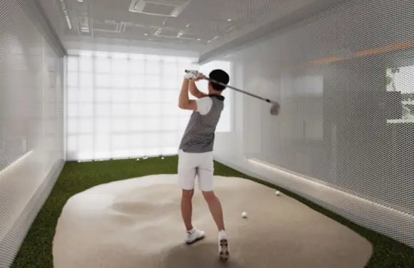 Beginner practicing golf swing basics with a GTBent indoor golf simulator for improved technique and consistency