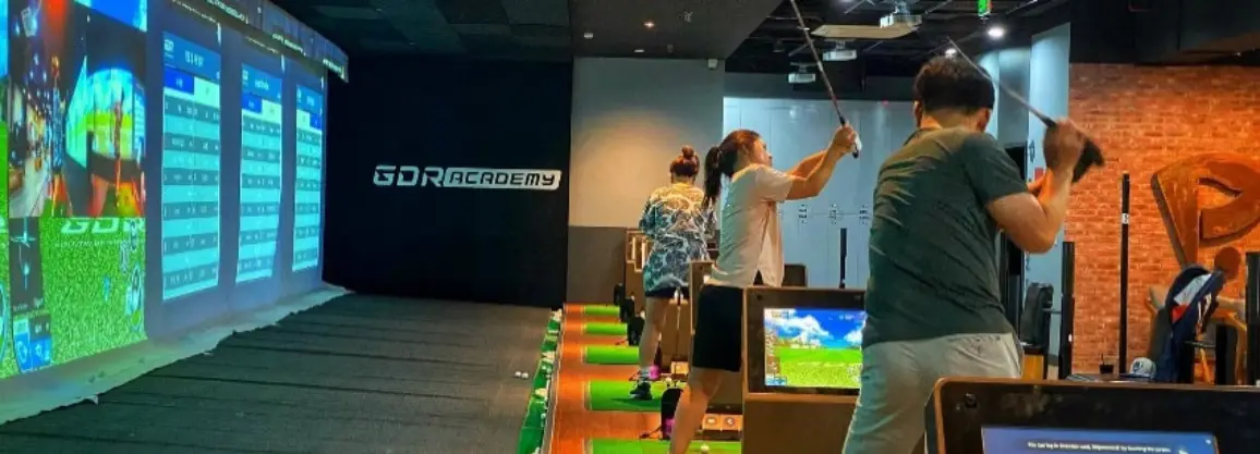 Golfers practicing with golf simulators to improve faster than the driving range through real-time swing analysis.