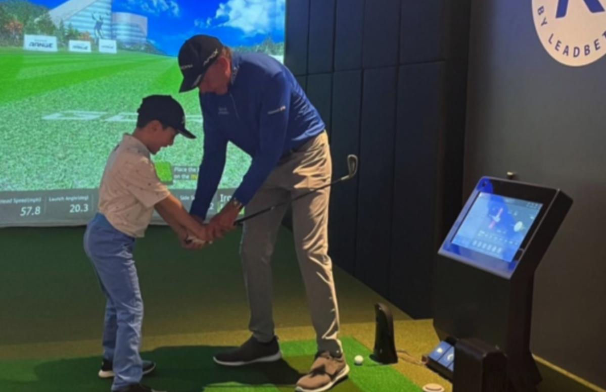 Instructor helping a beginner master the golf grip for a more consistent swing