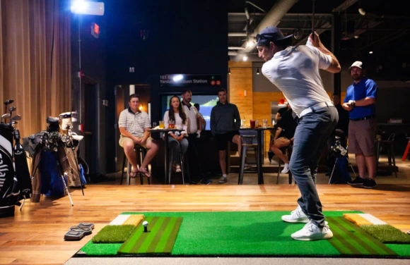 Golfer playing in a commercial GTBent golf simulator venue, illustrating how to start a commercial golf simulator business.